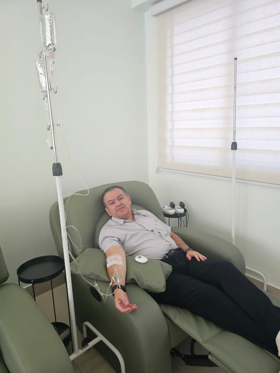 Davi Secundo recostado numa poltrona de tratamento, com soro ligado ao braço.